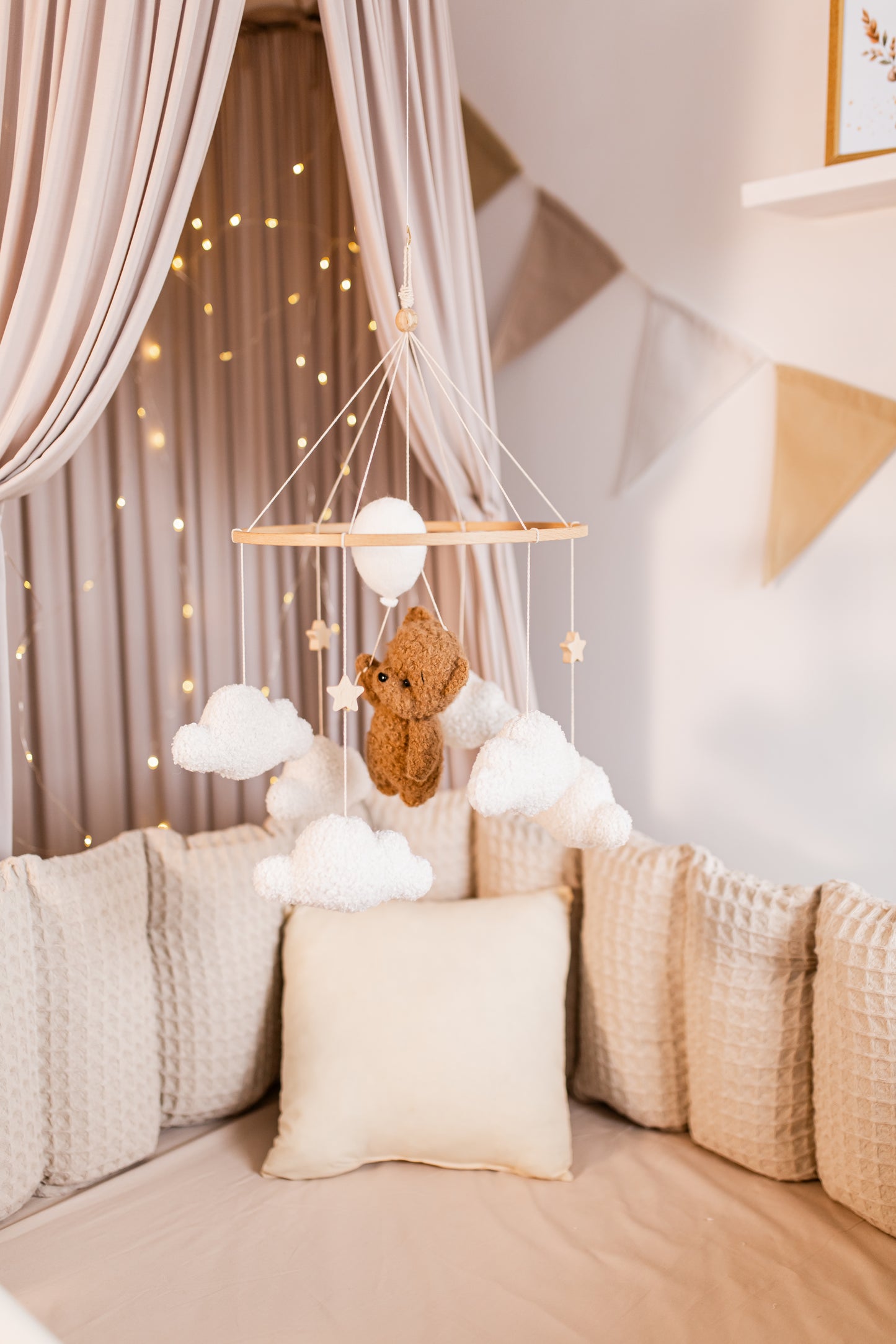 Hanging teddy bear mobile with clouds in a cozy room with soft lighting