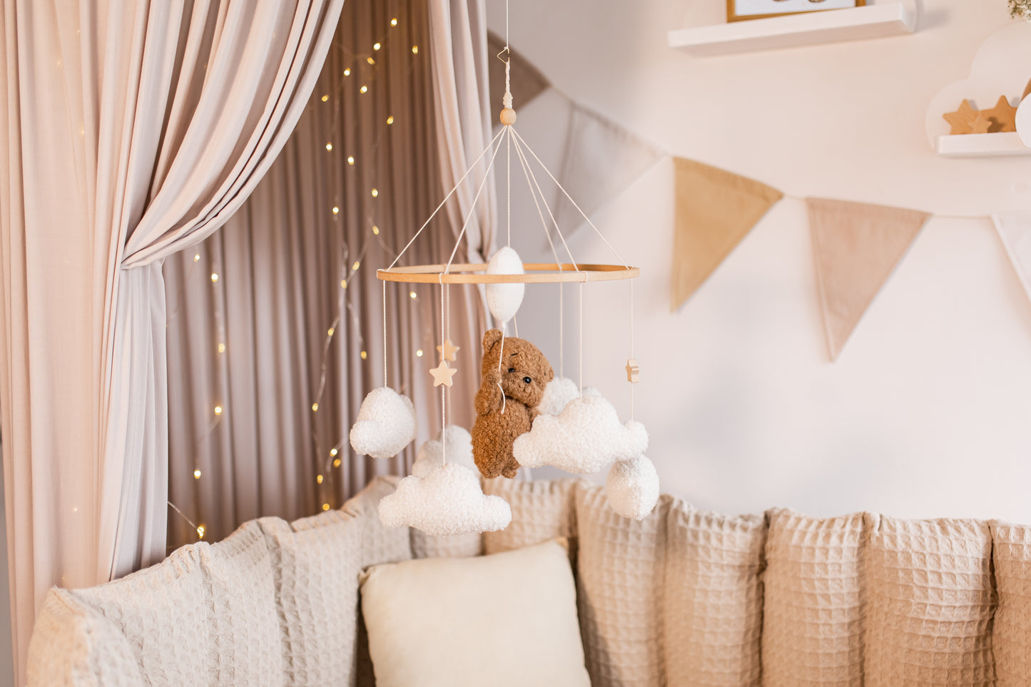 Children's room with a teddy bear mobile, and soft decorations.