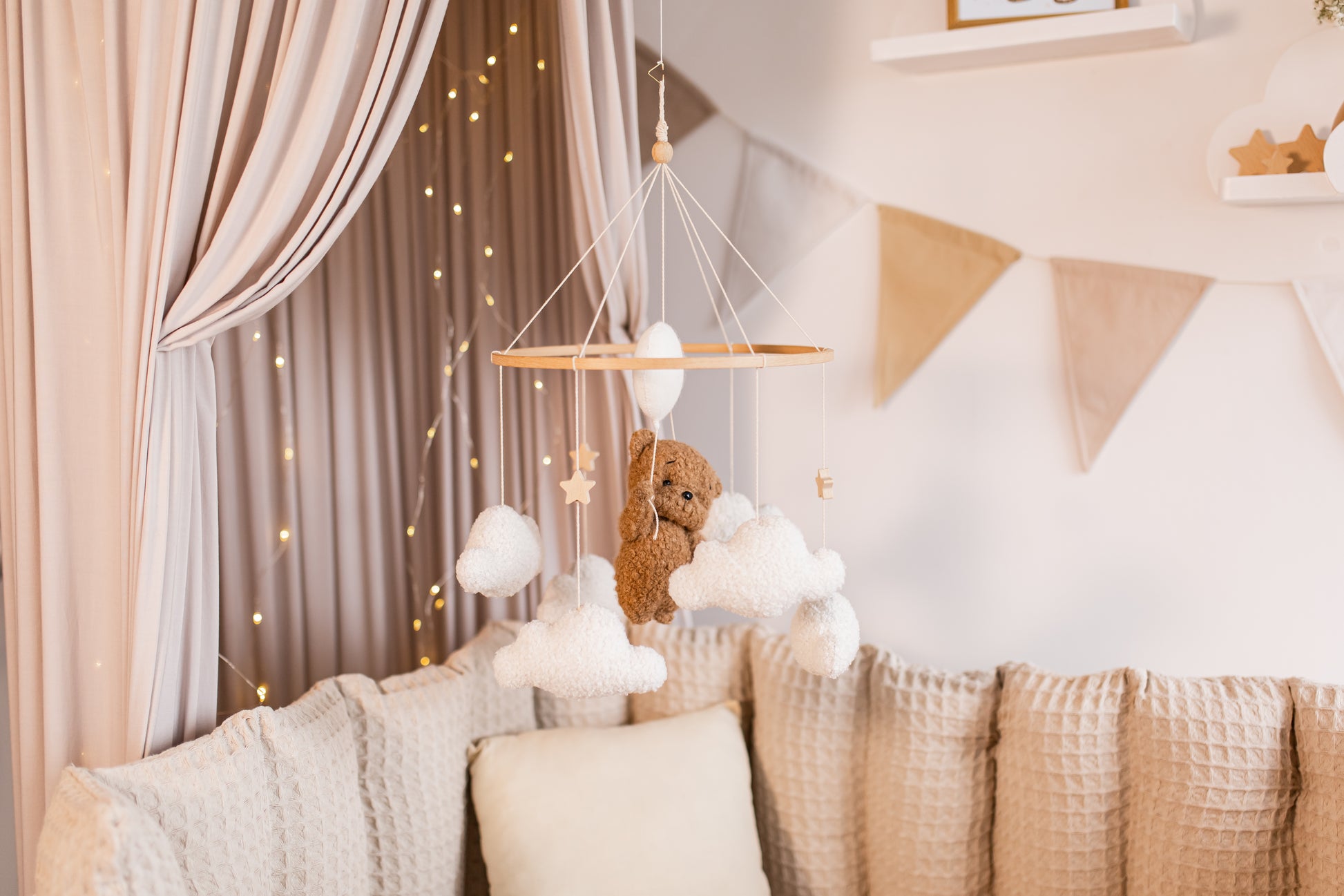 Children's room with a teddy bear mobile, and soft decorations.