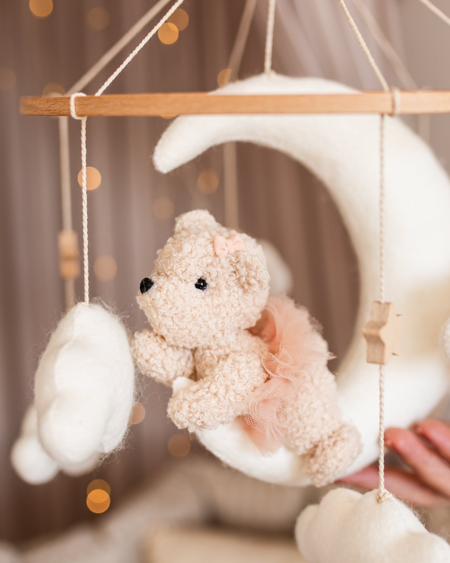 Boucle teddy bear mobile with clouds and stars hanging above crib