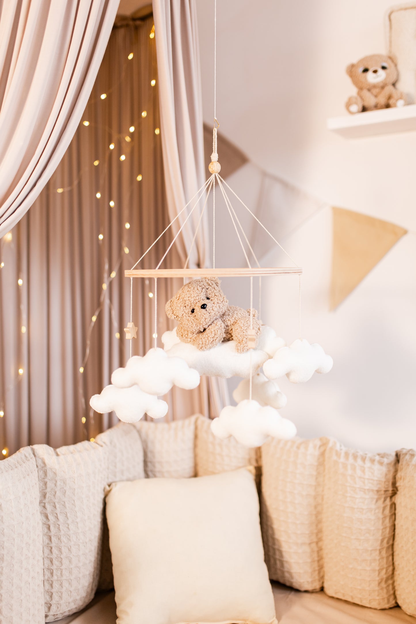 Children's room with teddy bear baby mobile, shelves, and fairy lights