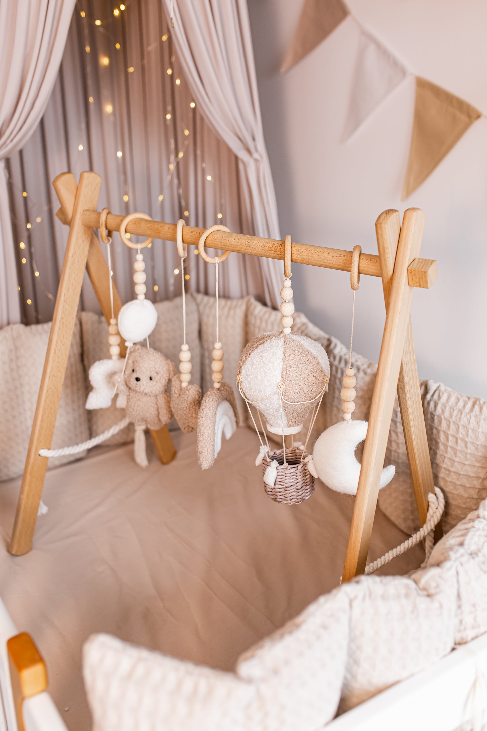 Wooden crib with hanging baby gym in a nursery setting