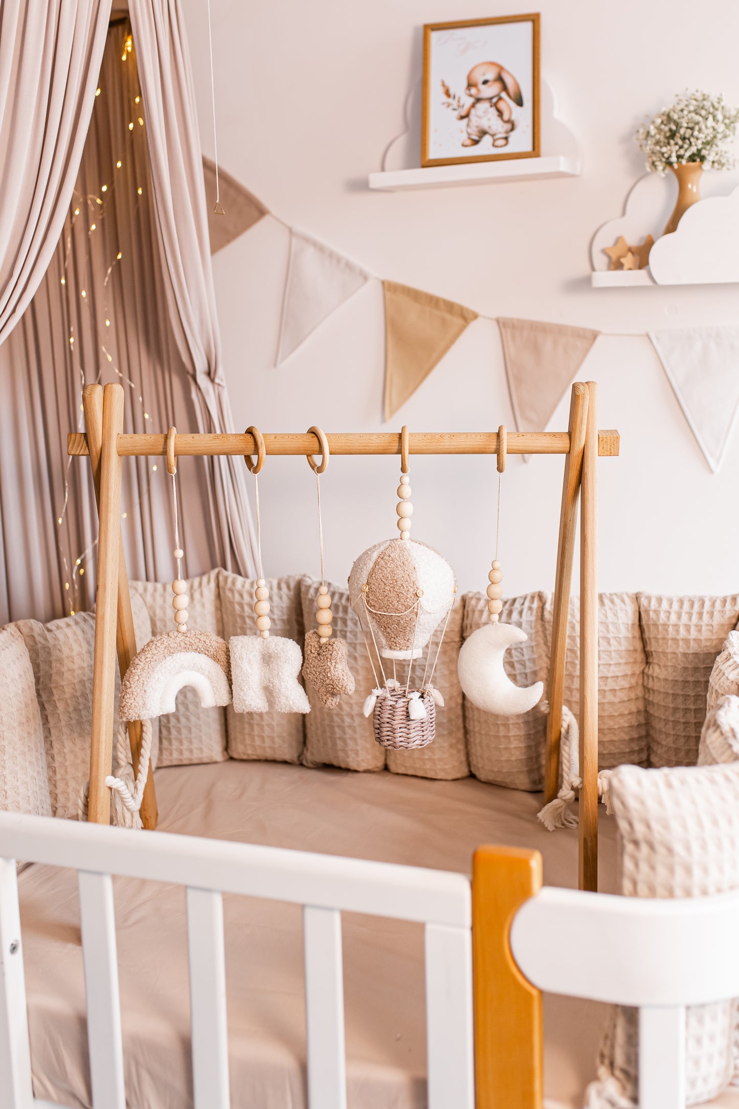 Nursery room with wooden crib, decorative pillows, and baby gym.