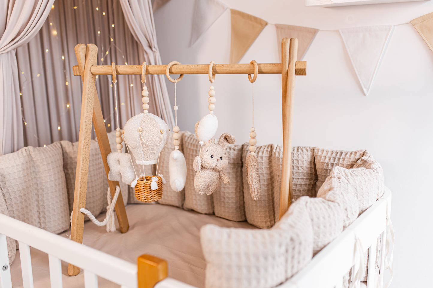 Baby crib with wooden toys bbay gym and decorative elements in a nursery setting