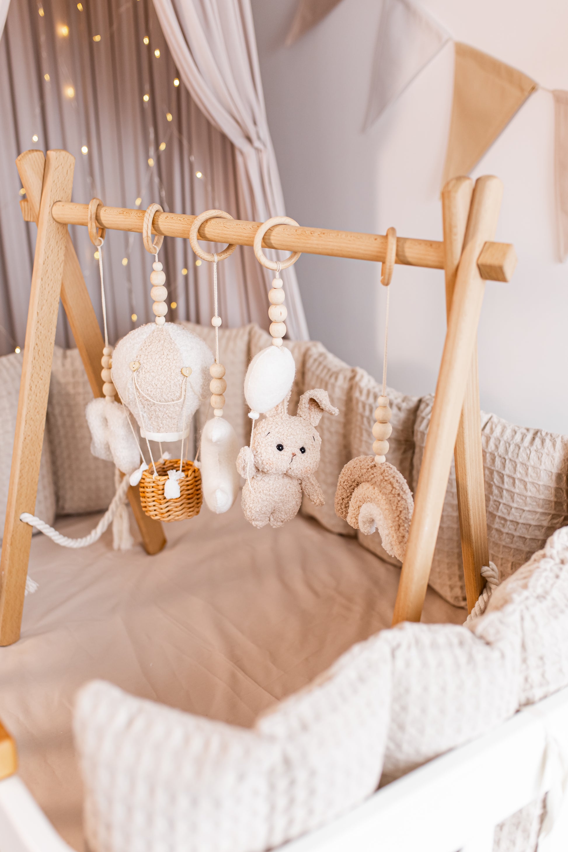 Wooden baby gym with hanging toys in a nursery setting