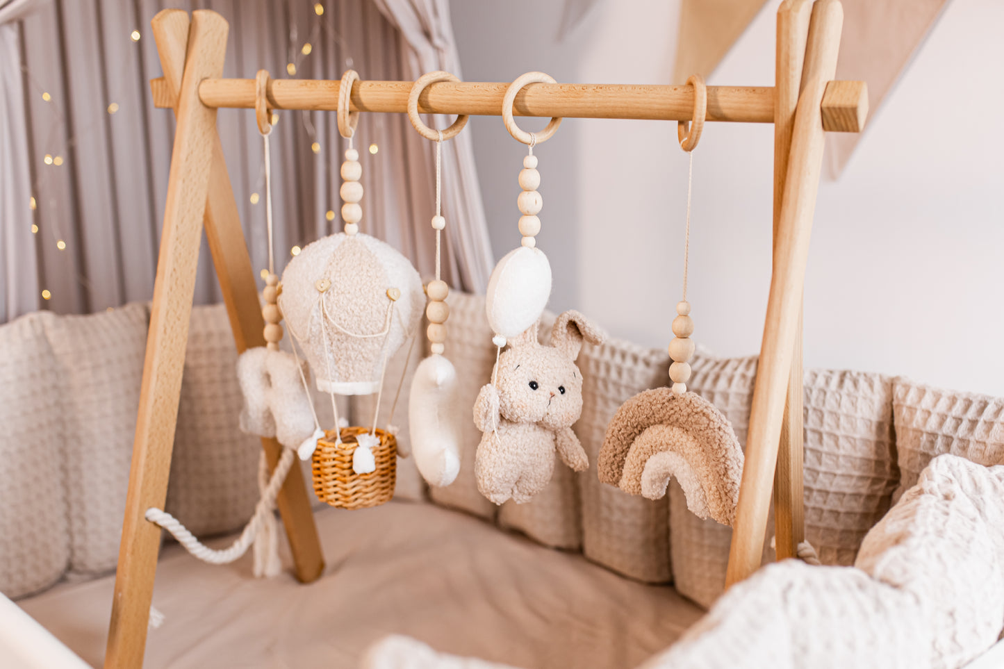 Wooden baby gym with nice soft hanging toys in a nursery setting