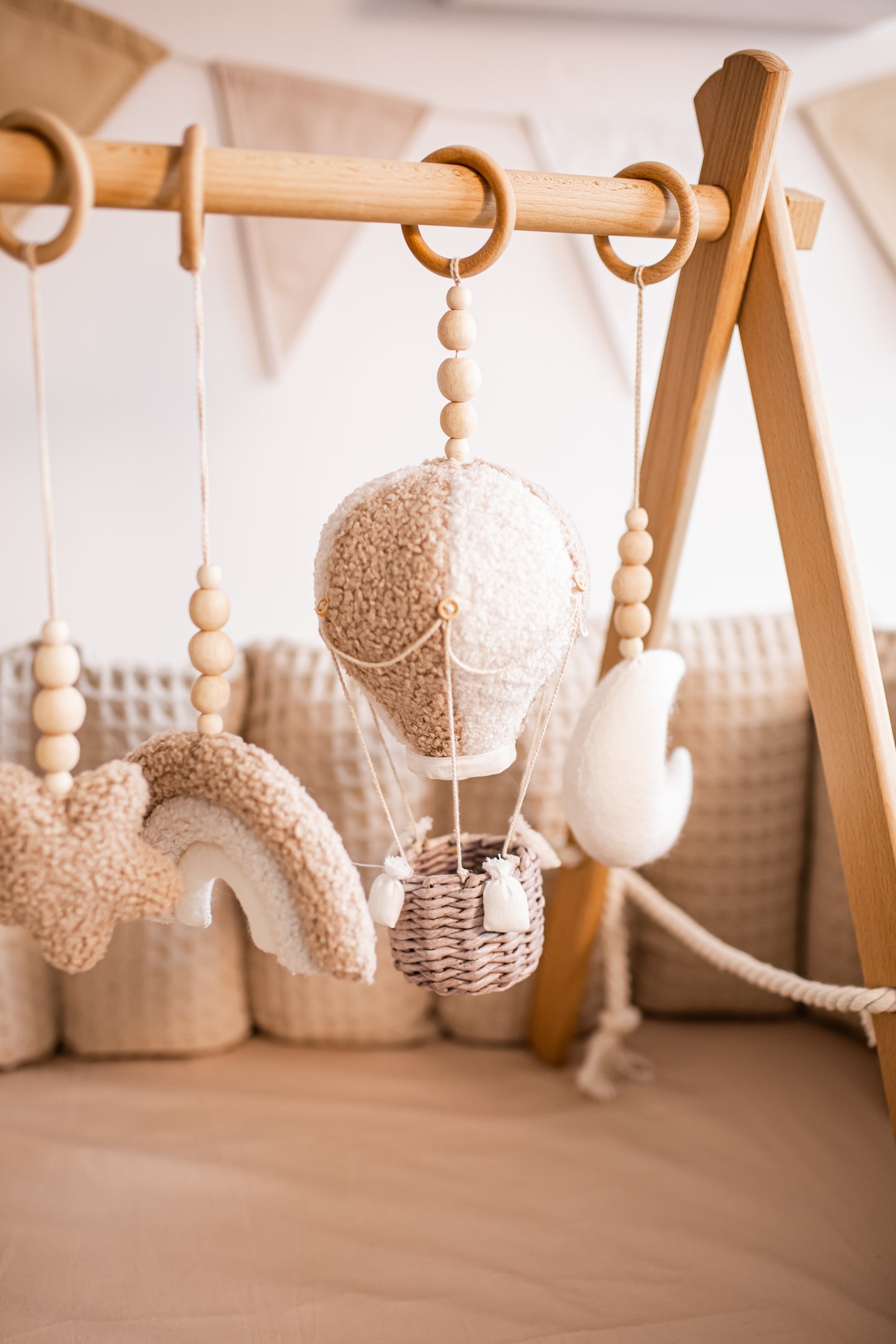 Decorative hanging baby gym with plush toys in a nursery setting.