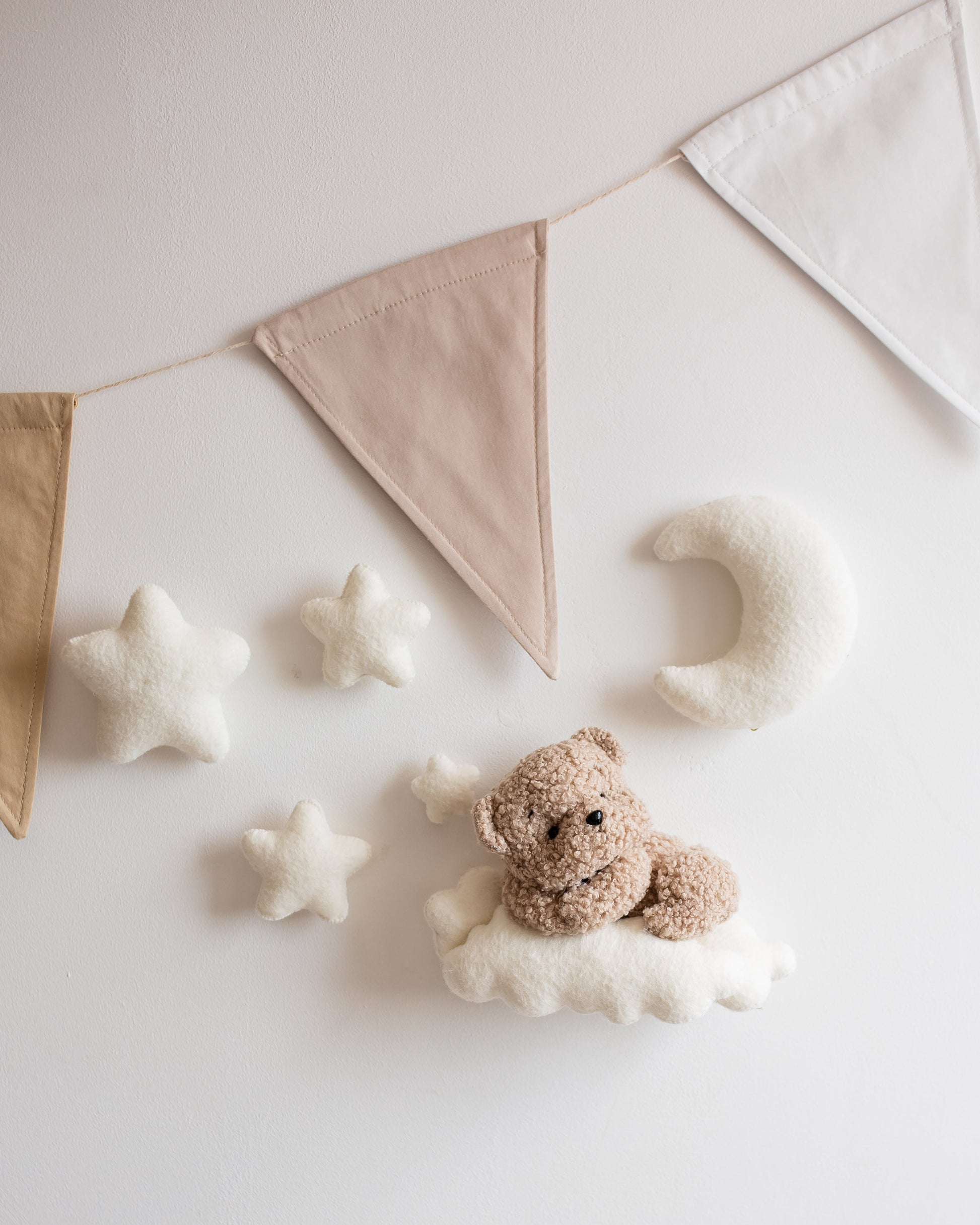 Bouclé bear on cloud wall décor with stars above nursery crib