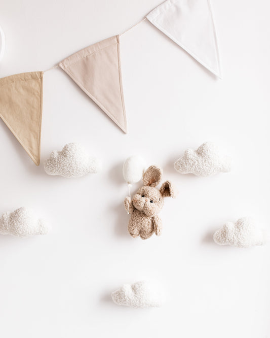 Bouclé bunny wall décor with balloon, clouds, and stars hanging near crib