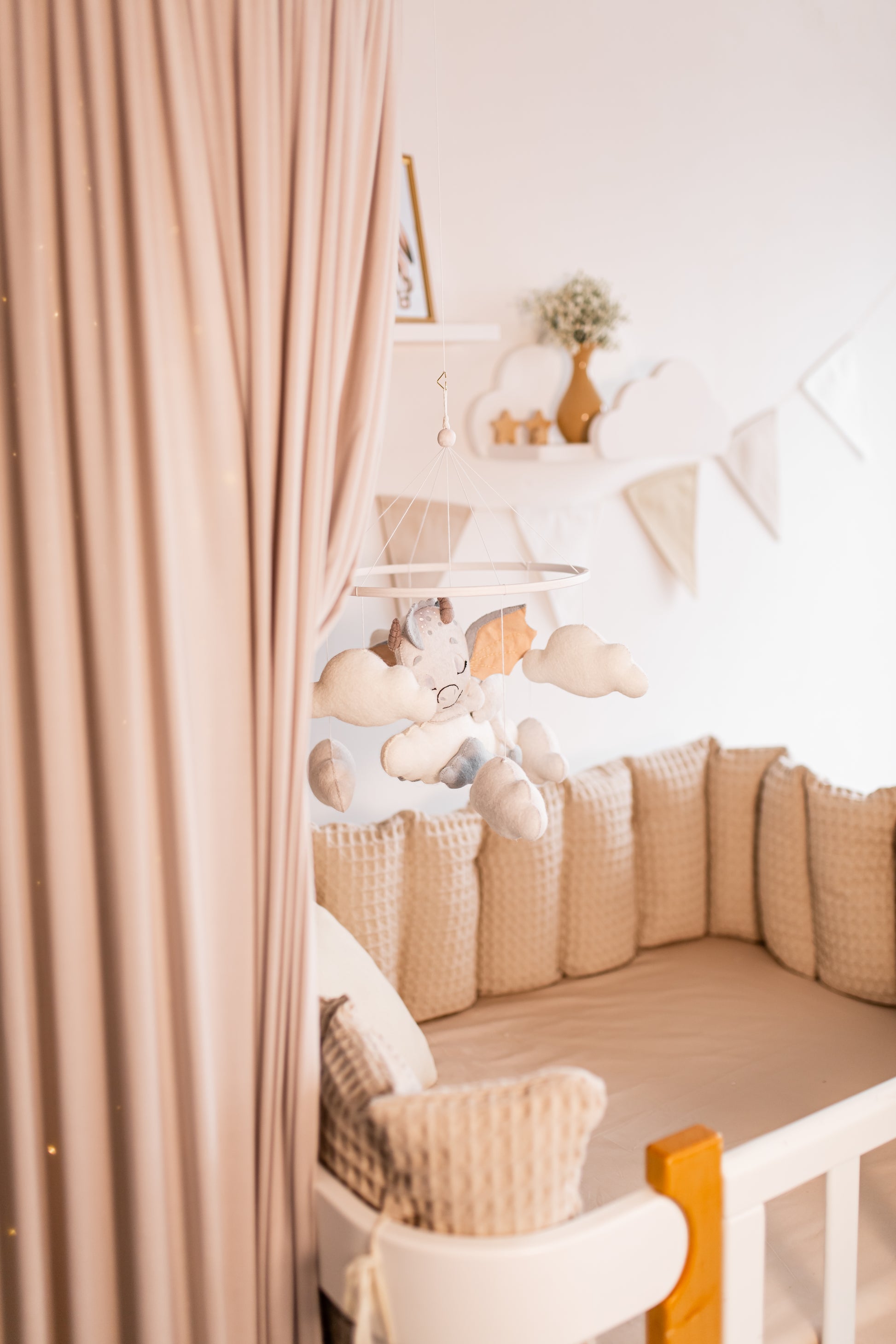 Nursery room with crib, dragon baby mobile and decorative elements.