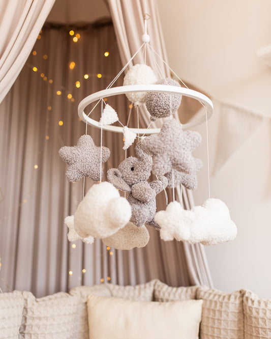 Boucle elephant baby mobile with stars and clouds above crib