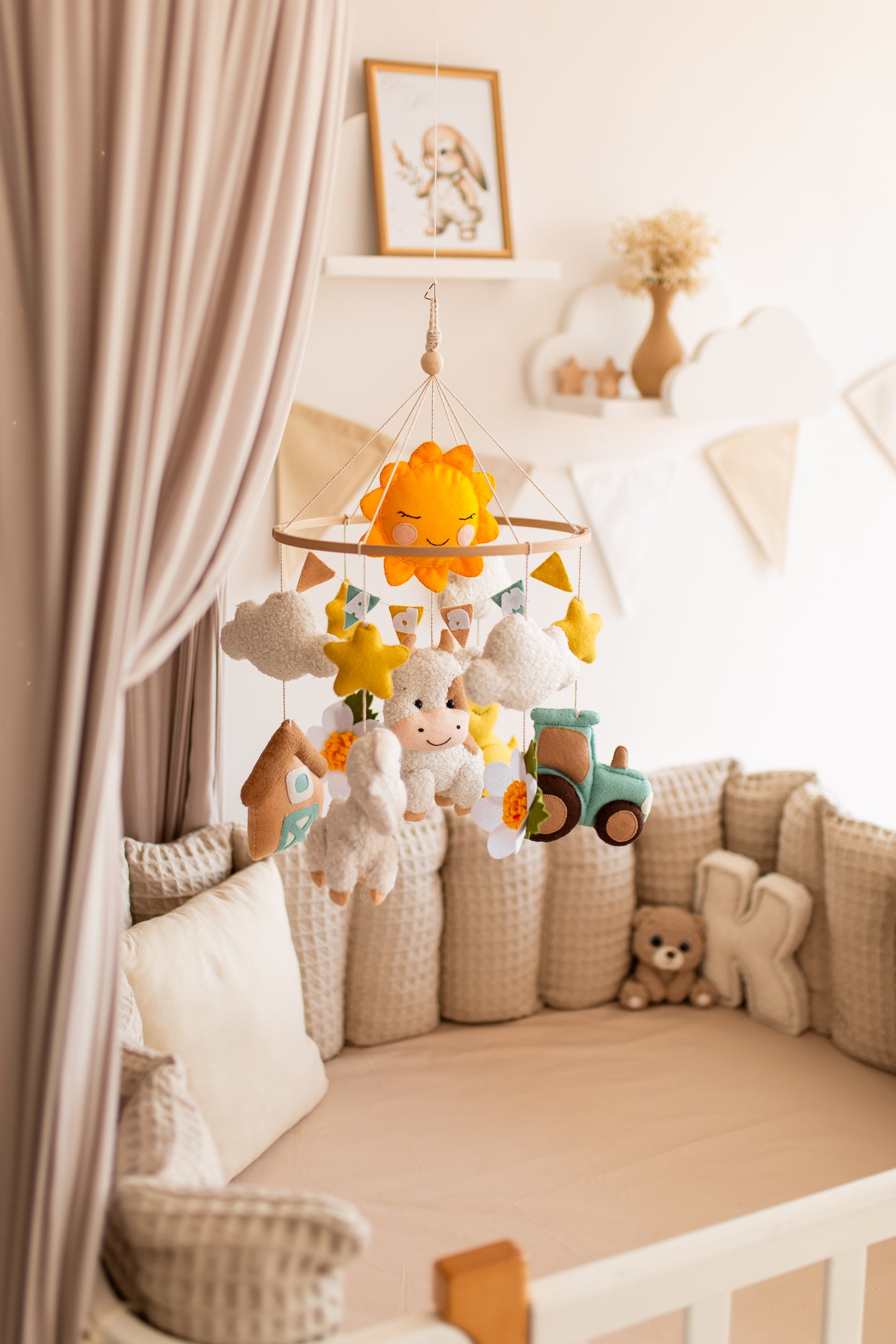 Children's crib with a mobile featuring farm animals, surrounded by soft bedding and toys.