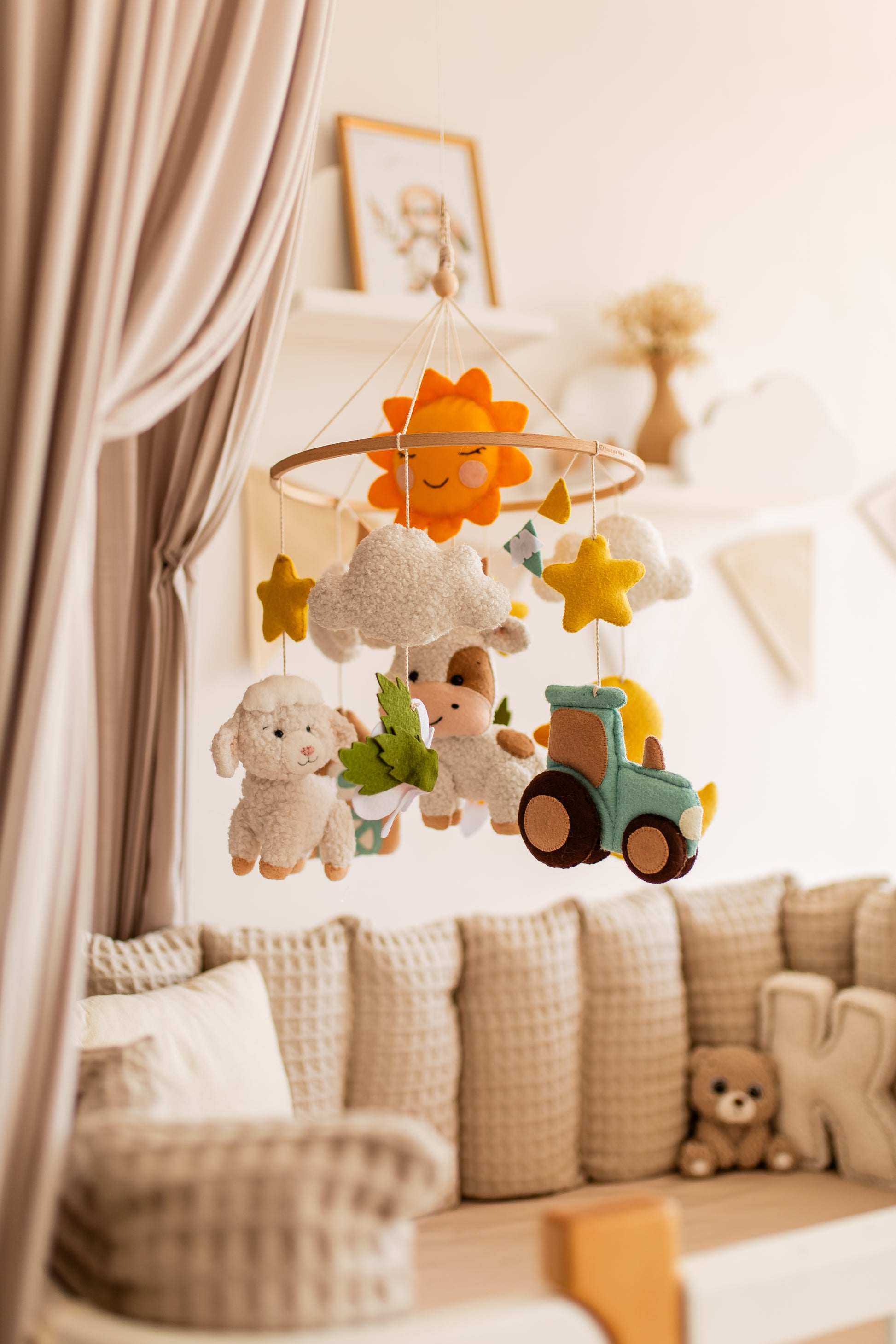 Children's mobile with toys hanging above a sofa in a nursery