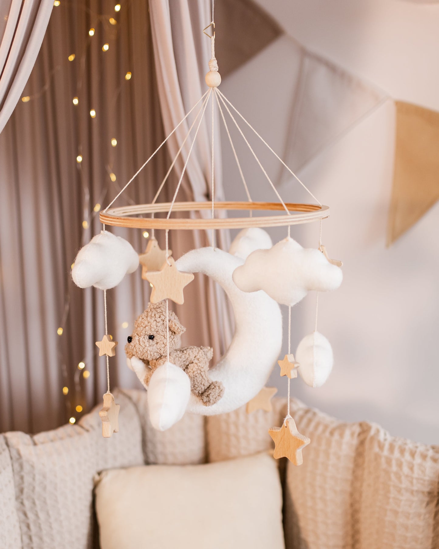 Boucle bear on crescent moon baby mobile with stars and clouds above crib