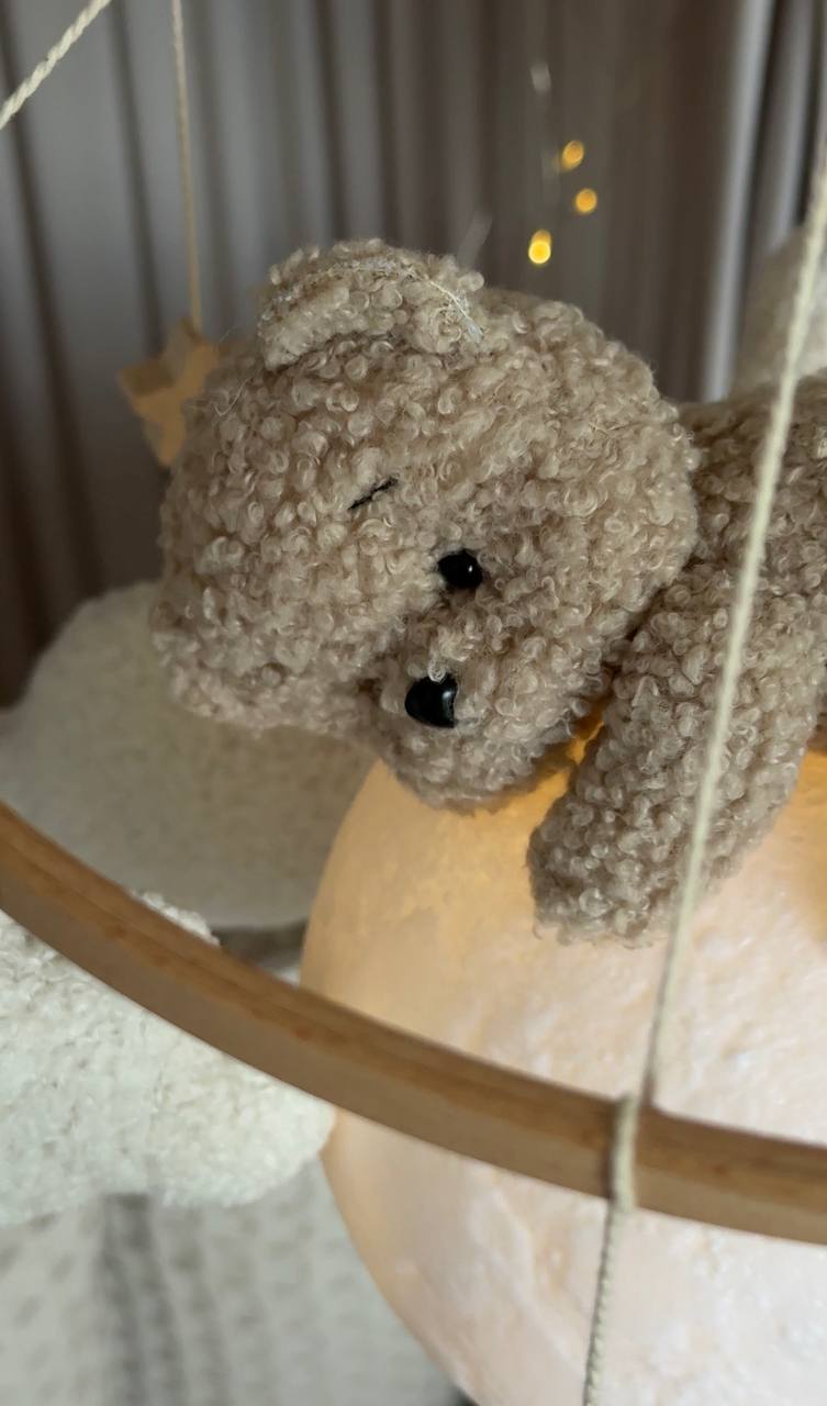 Bear baby mobile on a swing with a blurred background