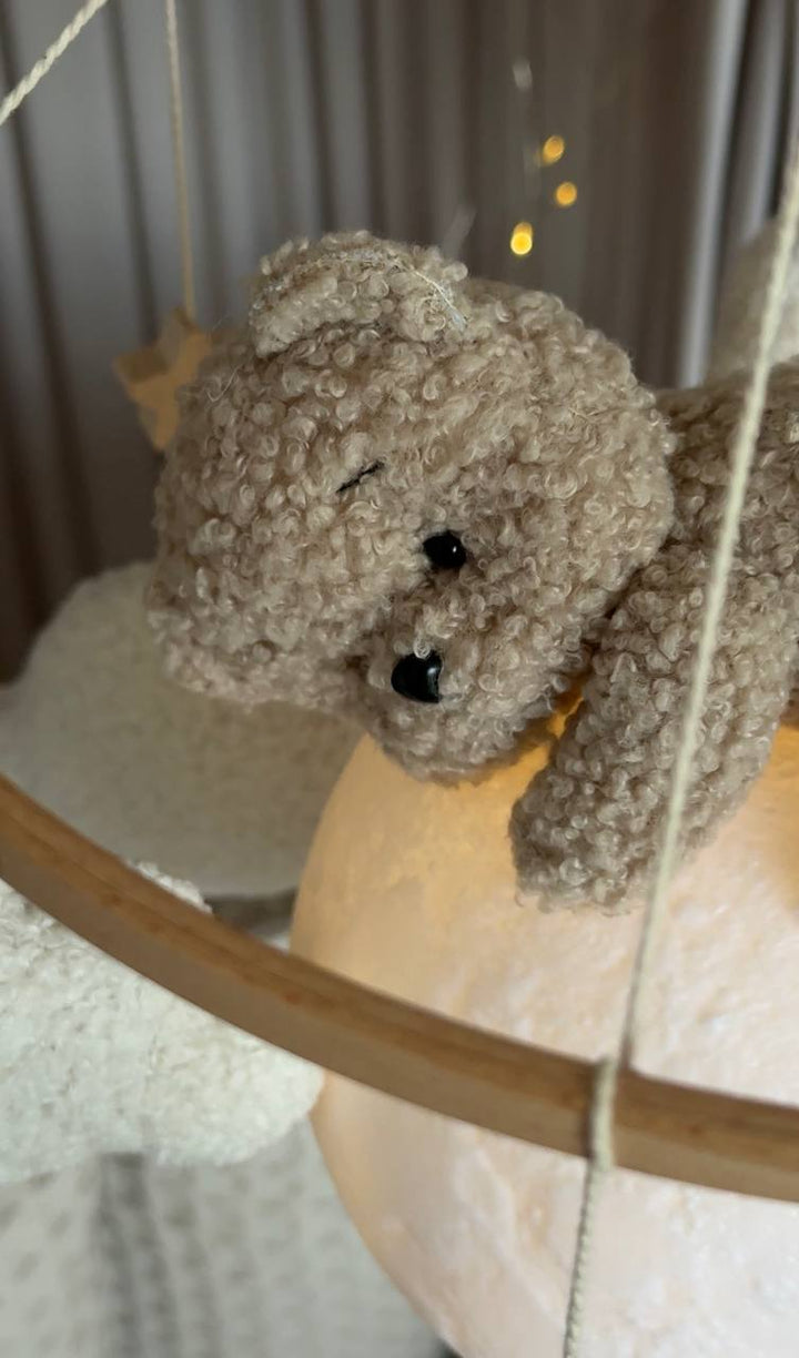 Bear baby mobile on a swing with a blurred background