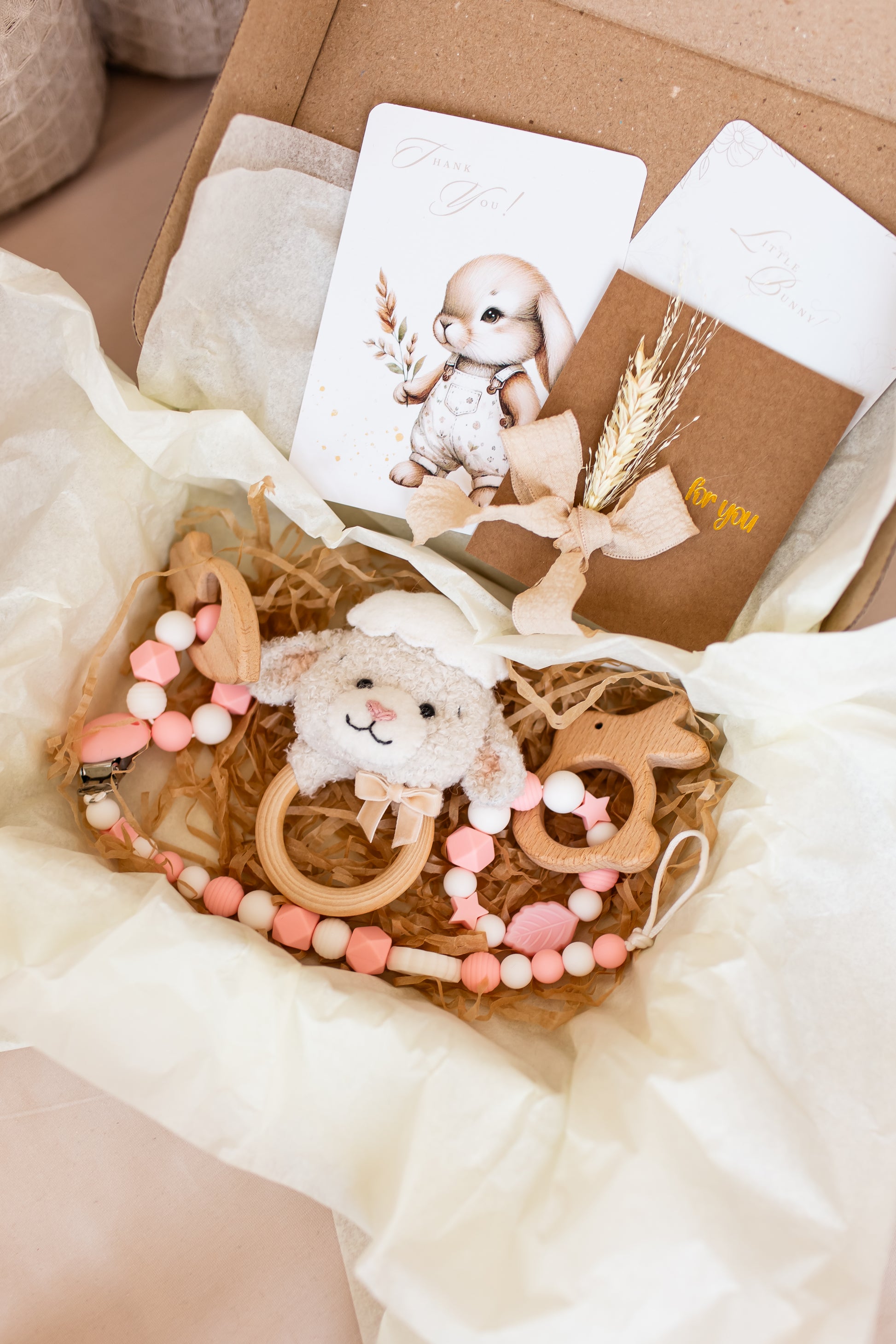 Baby toys and cards in a box with a soft white background