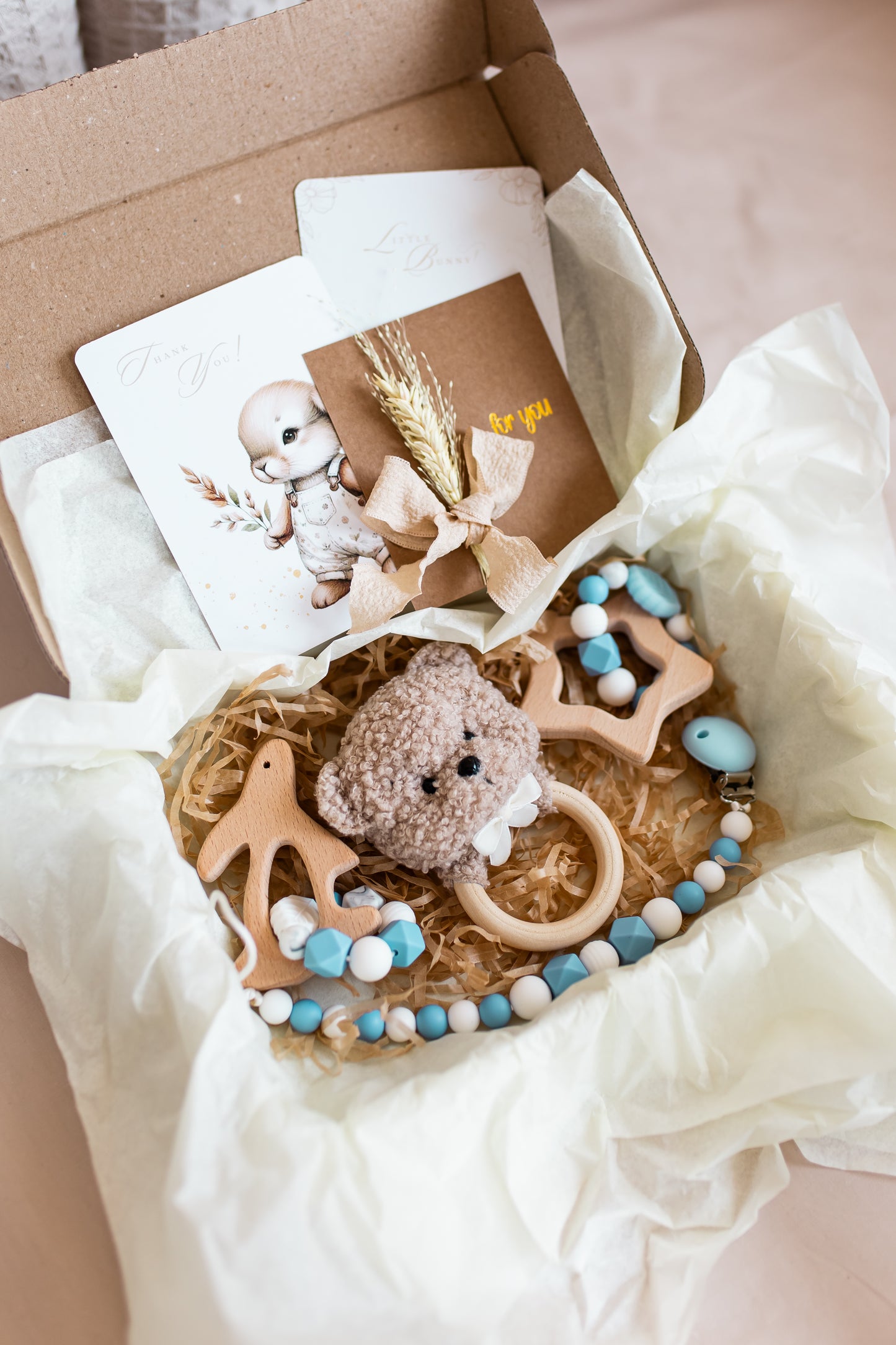 Baby toys and cards in a box on a light background