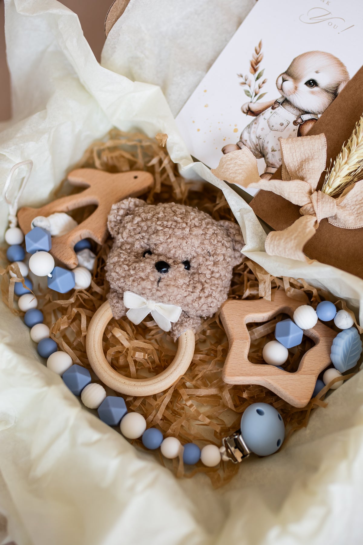 Baby teething ring with teddy bear toy and starfish-shaped toy in a heart-shaped box.