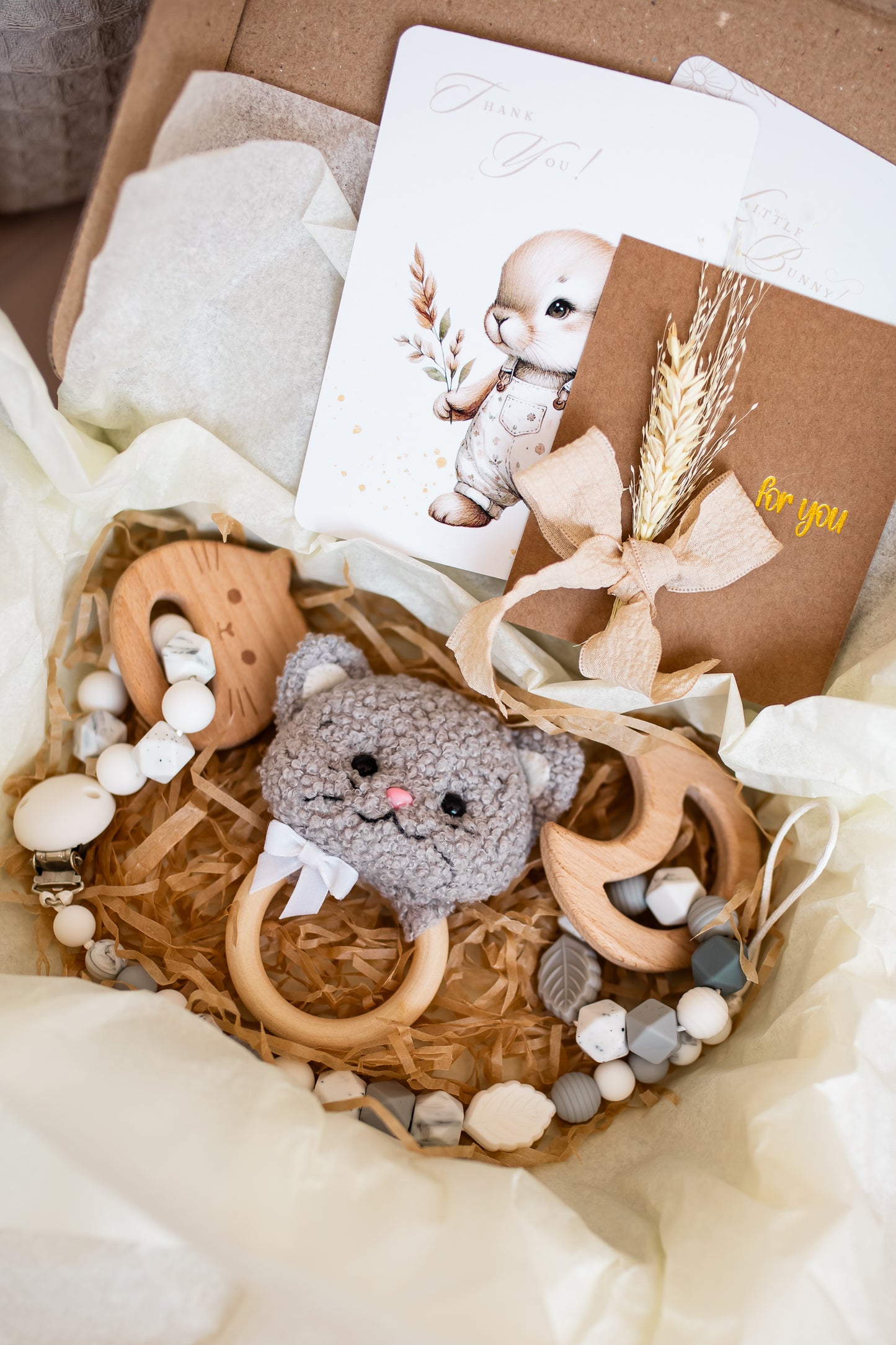 Baby toy set with plush animal, wooden teethers, and beads in a gift box.