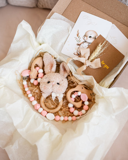 Bouquet of rabbit-shaped baby toys with a card in a box