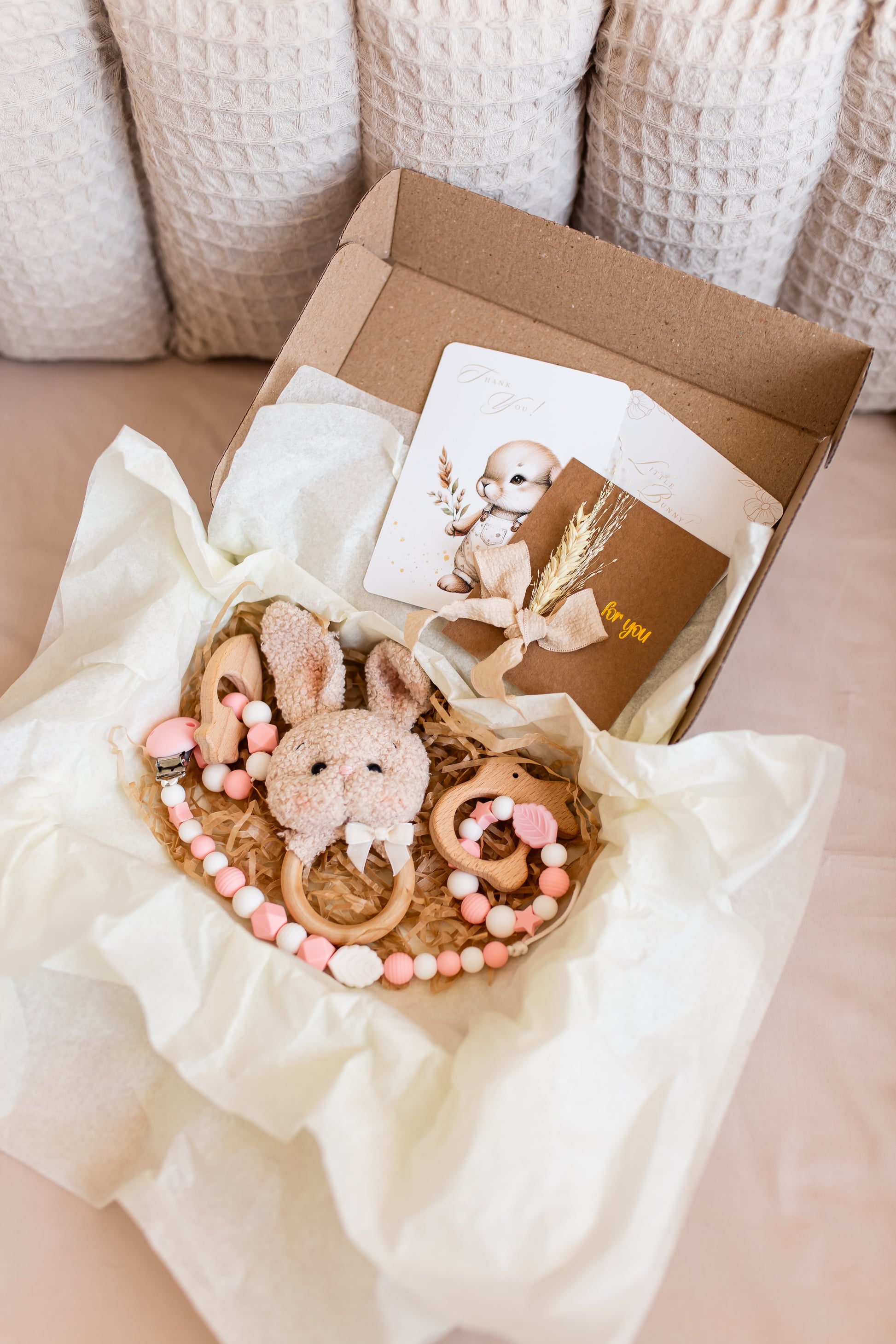 Bouquet of baby toys shaped like bunnies with a card on a white surface
