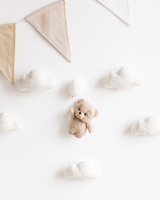 Bouclé teddy bear wall décor with balloon, clouds, and stars in nursery setting