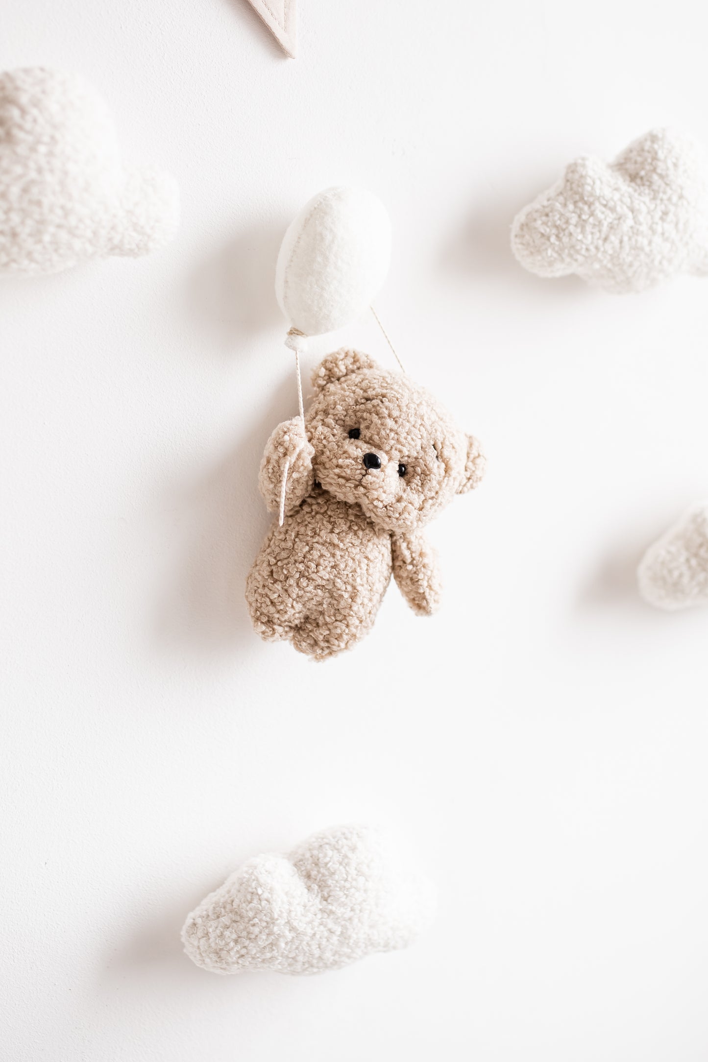 Handmade boucle teddy bear wall decoration with balloon and cloud accents