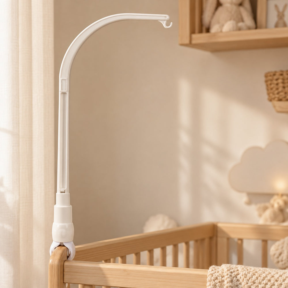 White plastic crib mobile holder with arched arm and clamp, mounted on a wooden crib